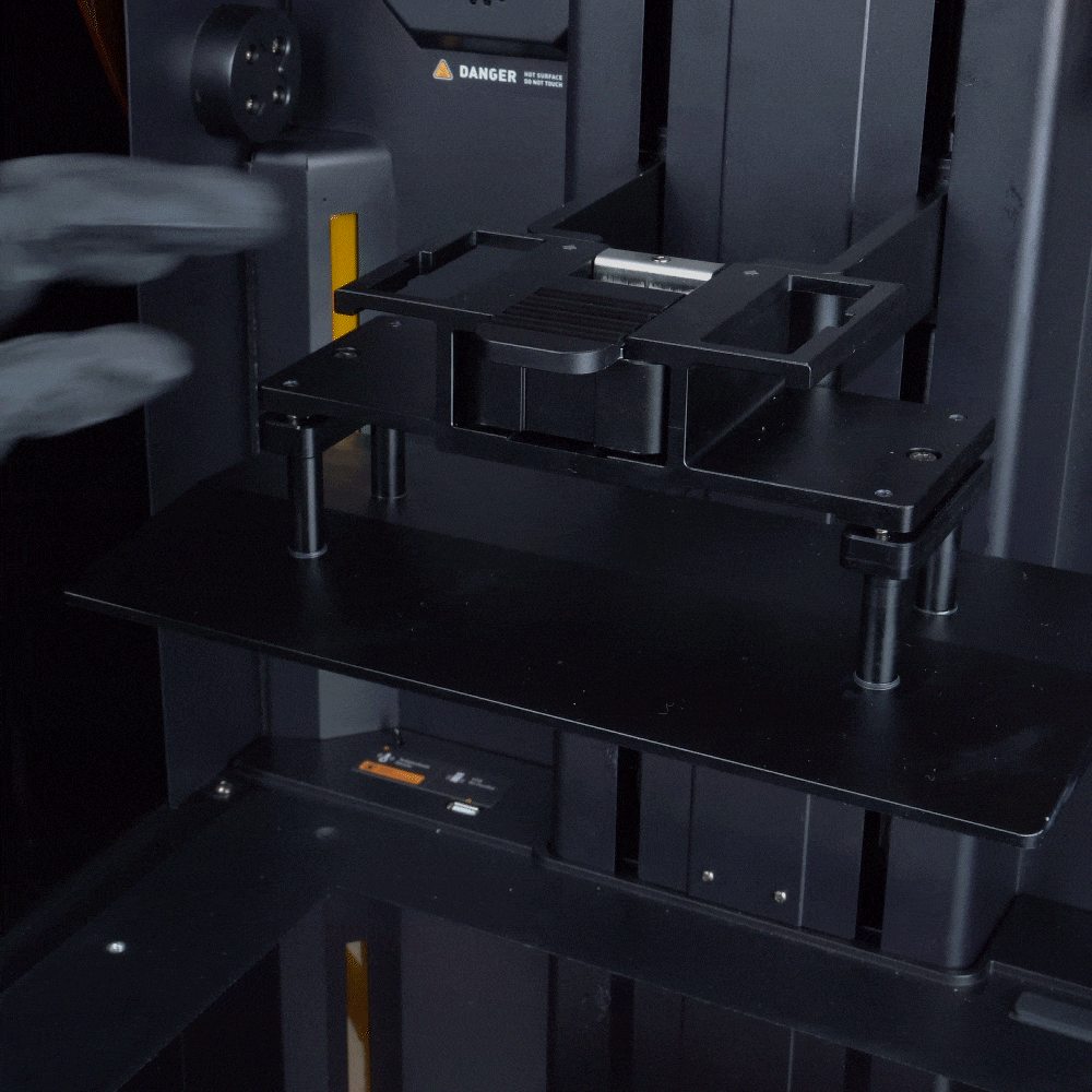GIF showing the build plate being removed and reinstalled by hand using the snap-lock latch and large side handles.